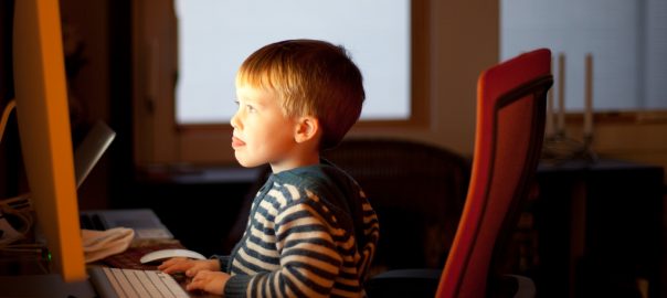 barn der sidder foran en computerskaerm