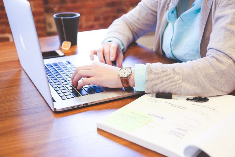 En person der sidder ved et skrivebord med en computer foran sig
