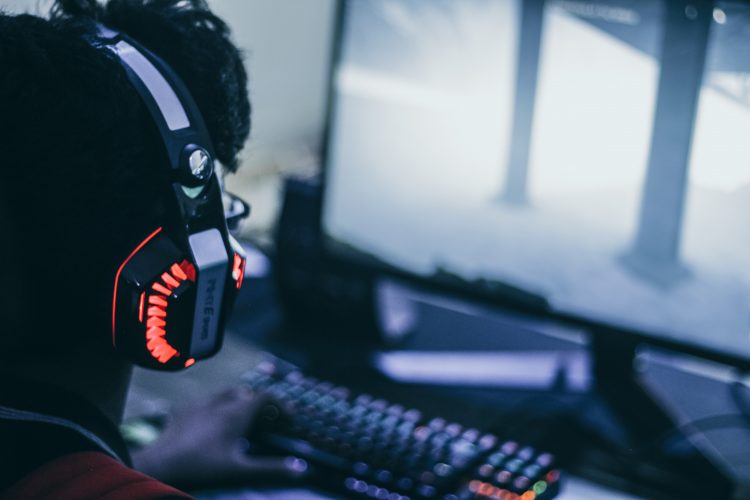 en person der spiller online spil med headset på